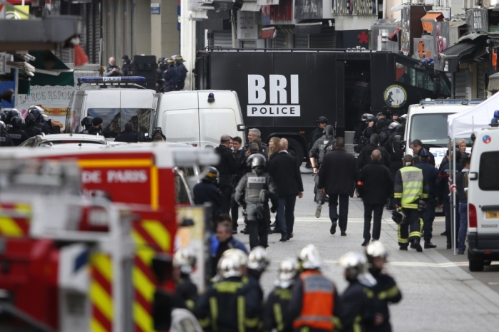 Members of French special police forces of the Research and Intervention Brigade work at the scene of the raid in Saint-Denis, near Paris, France, November 18, 2015 to catch fugitives from Friday night's deadly attacks in the French capital.