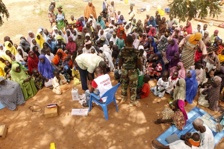 People who were rescued after being held captive by Boko Haram, sit as they wait for medical treatment at a camp near Mubi, northeast Nigeria October 29, 2015. Nigeria's armed forces on Wednesday said it had rescued 338 people held captive by Boko Haram and raided a number of the Islamist militant group's camps on the edge of its stronghold in the northeast's Sambisa forest.
