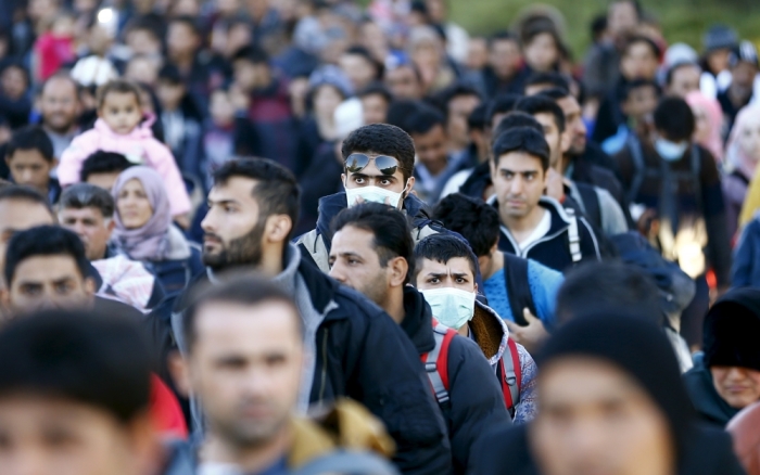 Migrants walk towards the Austrian border town of Spielfeld in the village of Sentilj, Slovenia, November 18, 2015. Austria announced plans on Friday (November 13) to build a 3.7-km (2.5-mile) fence on either side of its busiest border crossing with Slovenia to help manage the flow of thousands of migrants a day onto its territory.