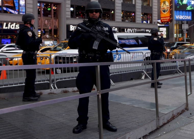 Armed New York City police officers with the special operation division Strategic Response Group stand in front of the U.S. Armed Forces Career Center at Times Square in New York, November 18, 2015.