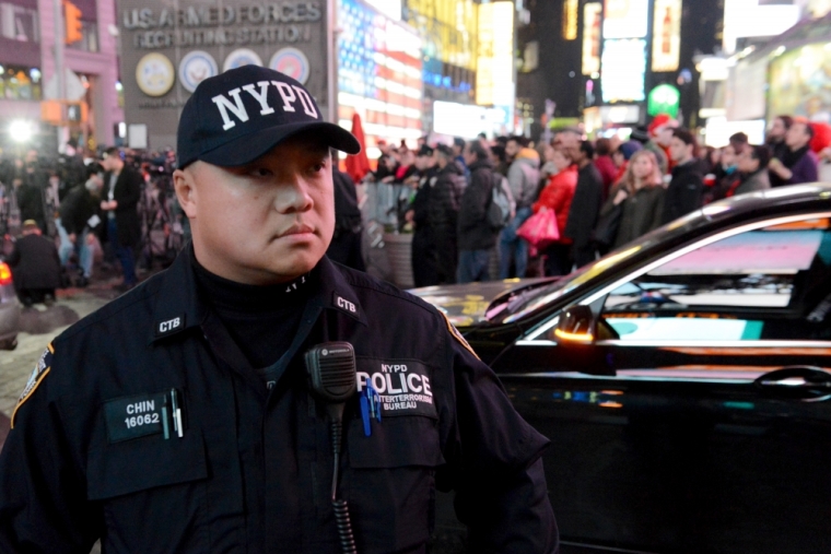 An armed New York City policeman stands guard in Times Square in the Manhattan borough in New York, November 18, 2015.