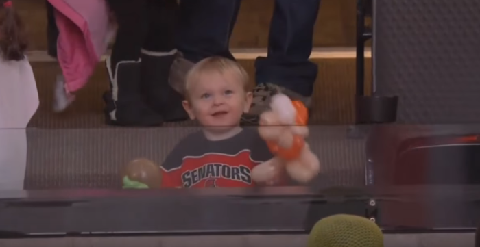 Kid gets attention from announcers for his lively activities during an Ottawa Senators game.