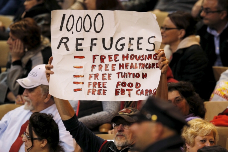 An audience member holds up an anti-refugee sign during a campaign rally with U.S. Republican presidential candidate Donald Trump in Worcester, Massachusetts, November 18, 2015.