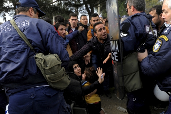 Greek policemen push back Syrian, Iraqi and Afghan refugees who tried to force their way through the Greek-Macedonian borders near the village of Idomeni, Greece November 22, 2015.