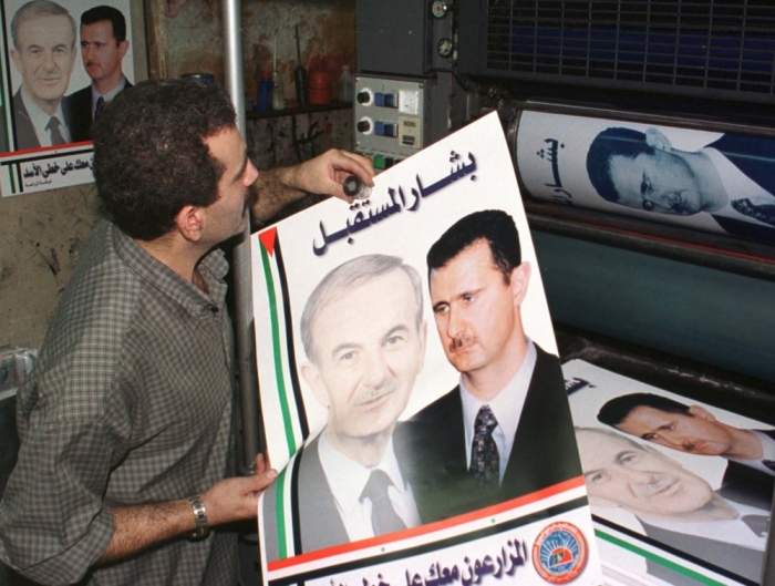 A Syrian printing press worker prepares July 1, 2000, pictures of Bashar al-Assad ahead of the July 10 referendum where he is the only candidate for the presidency. Bashar, a 34-year-old eye doctor, succeeds his father Hafez al-Assad, who died last month after 30 years as Syria's leader.