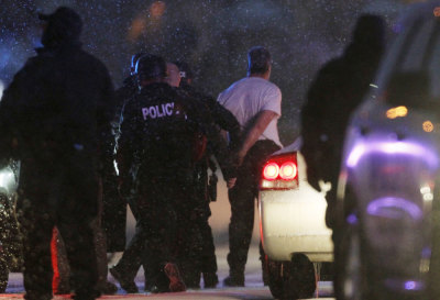 The handcuffed suspected gunman at the Planned Parenthood clinic is moved to a police vehicle in Colorado Springs, November 27, 2015.