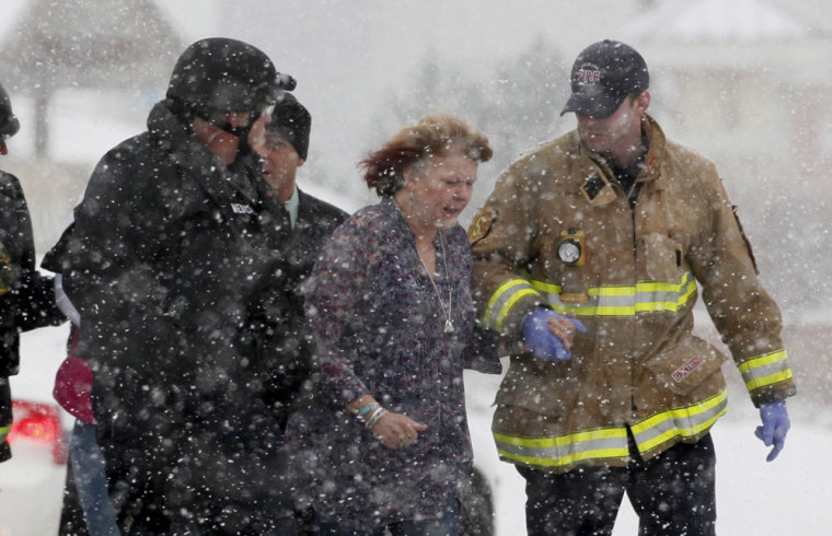 A woman is evacuated from a building where a shooter was suspected to be still holed up in Colorado Springs, November 27, 2015.