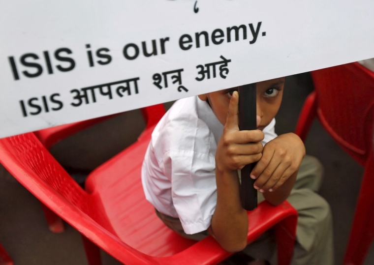 A Muslim boy looks on as he holds a placard at a rally organised by a Muslim charitable trust in Mumbai, India, November 26, 2015. The event was held to denounce ISIS and to spread knowledge about Islam, according to the organisers.