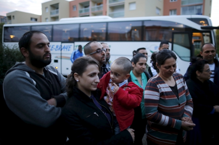 Christian Chierlos, 2 years old, looks at his motehr as he arrives with members of his family from Beirut, in Le Mans, France, October 2, 2015. A Syrian Christian family targeted by a September bomb attack in Damascus flew into Paris on Friday to start a new life, roughly a year after they requested entry visas from the French authorities.