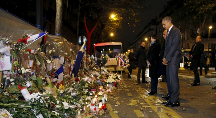 U.S. President Barack Obama, French President Francois Hollande and Paris Mayor Anne Hidalgo bow their heads as they visit a makeshift memorial at the Bataclan in Paris November 30, 2015.