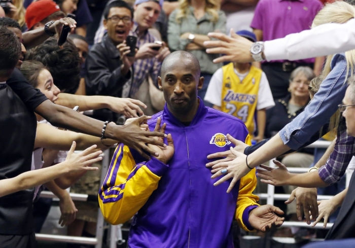 Los Angeles Lakers guard Kobe Bryant walks past fans before the second half of their NBA basketball game against the Utah Jazz in Salt Lake City, Utah, November 7, 2012.