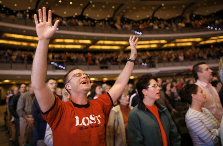 A parishioner cries as he signs a song of worship in the 7,000-seat Willow Creek Community church during a Sunday service in South Barrington, Illinois, November 20, 2005. Institutions like Willow Creek and Houston's Lakewood Church, each drawing 20,000 or more on a weekend, offer not just a vast, shared attraction but a path that tries to link individuals on a faith-sustaining one-to-one level beyond the crowd, observers and worshipers say.