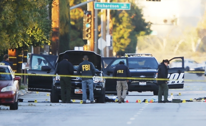 FBI and police investigator are seen around a vehicle in which two suspects were shot following a mass shooting in San Bernardino, California, December 3, 2015. Authorities on Thursday were working to determine why Syed Rizwan Farook, 28, and Tashfeen Malik, 27, who had a 6-month-old daughter together, opened fire at a holiday party of his co-workers in Southern California, killing 14 people and wounding 17 in an attack that appeared to have been planned.