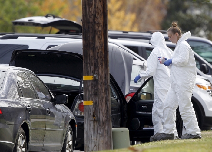 FBI agents look over a vehicle in front of a residence, that is in connection to Wednesday's shootings at theInland Regional Center, in San Bernardino, California December 3, 2015.