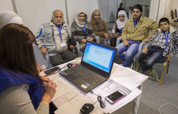A family of Syrian refugees are interviewed by authorities in hope of being approved for passage to Canada at a refugee processing centre in Amman, Jordan, November 29, 2015.