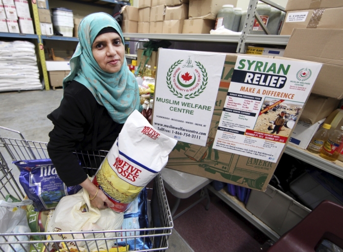 Uzma Anjum sorts and packs non-perishable food donations destined for Syrian refugees in Lebanon's Bekaa Valley, at the Muslim Welfare Centre in Scarborough, Ontario, November 24, 2015.