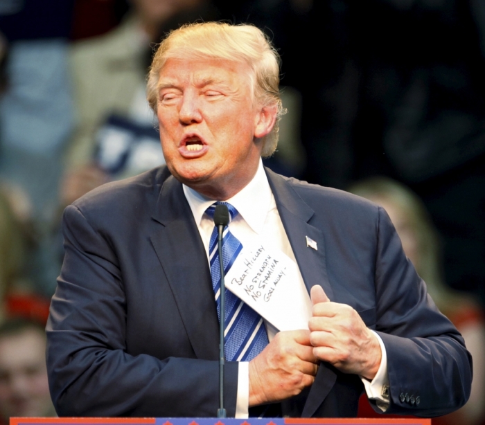 U.S. Republican presidential candidate Donald Trump puts his notes back in his jacket after talking about Democrat opponent Hillary Clinton at a Trump for President campaign rally in Raleigh, North Carolina December 4, 2015. The notes read, 'Beat Hillary, No Strength, No Stamina, Goes Away'.