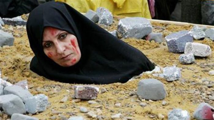 For this undated photo, an Iranian woman symbolically dressed up as a victim of death by stoning as part of a protest by the National Council of Resistance of Iran in Brussels.