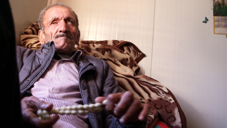A visually impaired Iraqi refugee fingers beads.