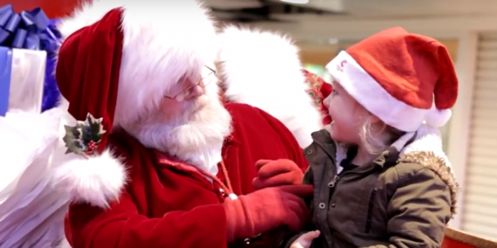 Santa Clause asking kid what she wants for Christmas.