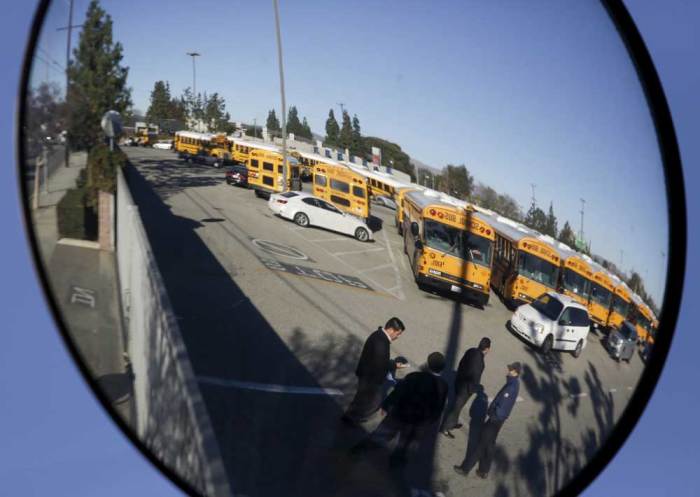 A Los Angeles Unified School District (LAUSD) school bus yard is reflected in a mirror in the North Hills neighborhood of Los Angeles, California December 15, 2015. All schools in Los Angeles, the second largest school district in the United States, were closed on Tuesday after officials reported receiving an unspecified threat to the district and ordered a search of all schools in the city.
