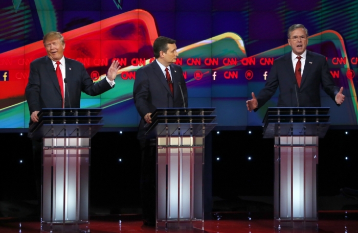 Republican U.S. presidential candidate businessman Donald Trump (L) responds to criticism from former Governor Jeb Bush (R) as Senator Ted Cruz (C) looks on during the Republican presidential debate in Las Vegas, Nevada December 15, 2015.