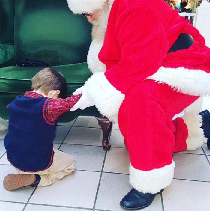 4-year-old Prestyn Barnette prays with Santa Clause at the Dutch Square Mall at Columbia, South Carolina during the 2015 Christmas season.