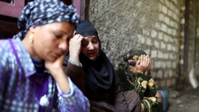 The cousin, mother and wife (L-R) of Samuel Alham, one of 27 Egyptian Coptic Christian workers kidnapped in the Libyan city of Sirte, mourns in front of the family's house in Al-Our village, in Minya governorate, south of Cairo, Jan. 21, 2015.