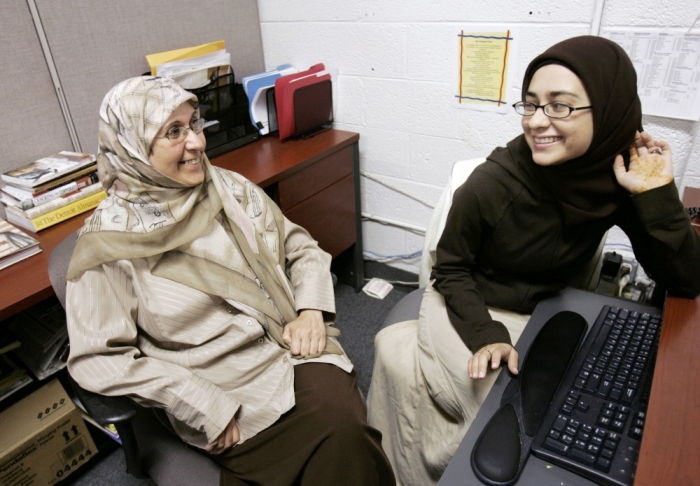 Zainab Theresia Huber (L), a 51-year-old Muslim convert, talks with 21-year-old Sofia Latif, as they wear their Muslim hijabs while at work at a social services agency that services a mostly immigrant clientele in Dearborn, Michigan, August 20, 2007.