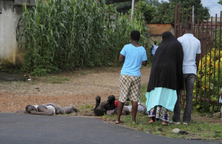 Residents look at bodies of unidentified men killed during gunfire, in the Nyakabiga neighbourhood of Burundi's capital Bujumbura, December 12, 2015. At least 20 dead bodies were seen on the streets of the Burundian capital Bujumbura on Saturday, a police source said, following the worst outbreak of violence since a failed coup in May.