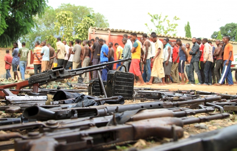 Suspected fighters are paraded before the media by Burundian police near a recovered cache of weapons after clashes in the capital Bujumbura, Burundi, December 12, 2015.