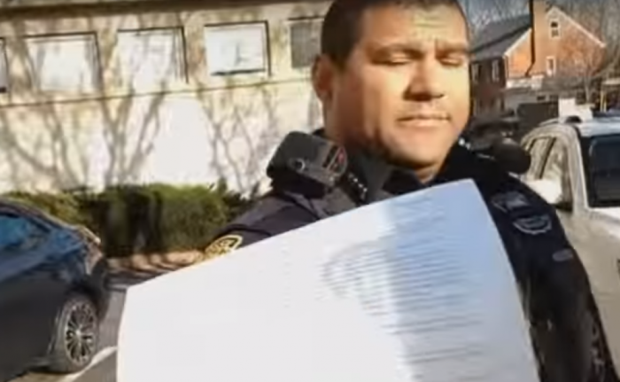 Officer shows pro-life Christmas carolers ordinance to prevent them from singing outside abortion clinic.