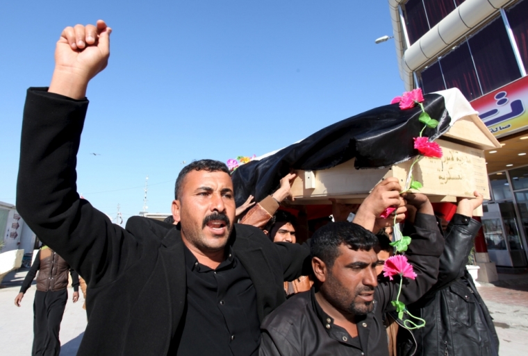 Mourners carry the coffin of a member from the Iraqi security forces, who was killed in the city of Ramadi, during the funeral in Najaf, south of Baghdad, December 28 2015.