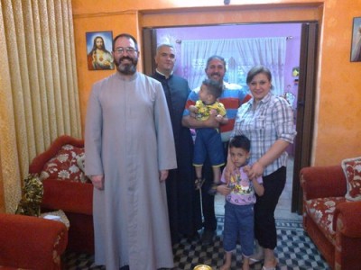 Father Luis Montes with a Iraqi Christian family.