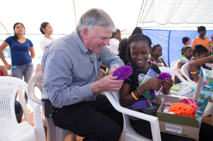 Franklin Graham delivers an Operation Christmas Child gift-filled shoebox to a child in Belize on Dec. 28, 2015.