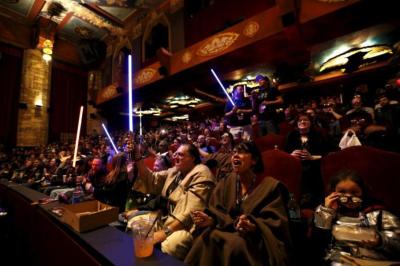 Moviegoers cheer and wave lightsabers before a showing of 'Star Wars: The Force Awakens' at the TCL Chinese Theatre in Hollywood, California, Dec. 17, 2015.