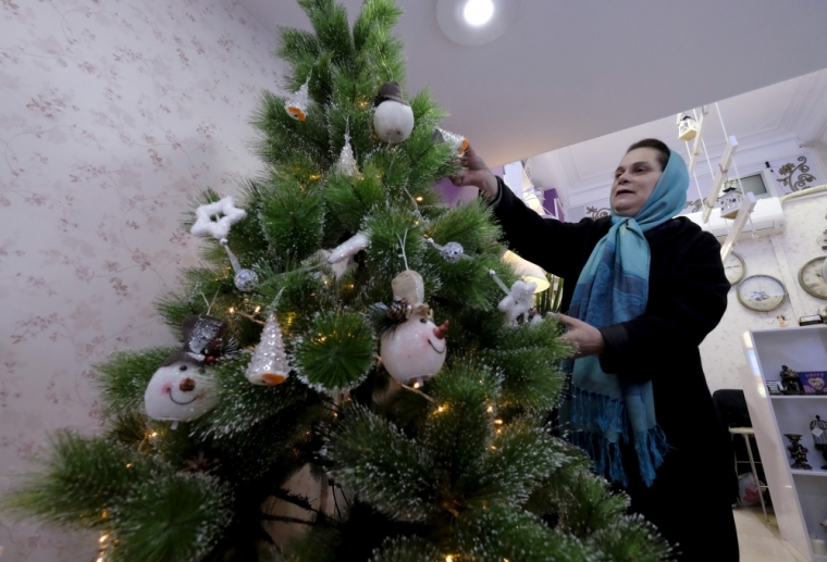 An Iranian Christian woman checks a Christmas tree at a shop in central Tehran, December 23, 2015.