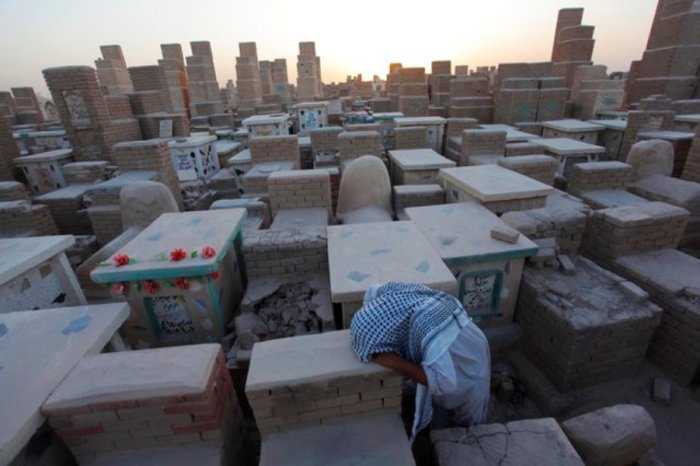 A man grieves at a cemetery in Najaf, south of Baghdad September 15, 2014.