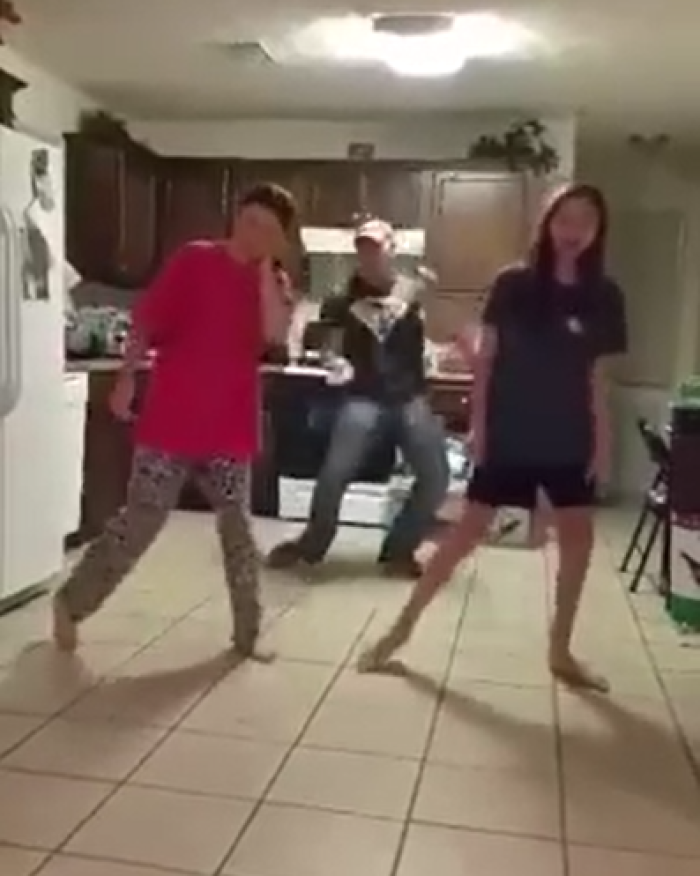 Dad photobombs daughters as they dance in viral video.