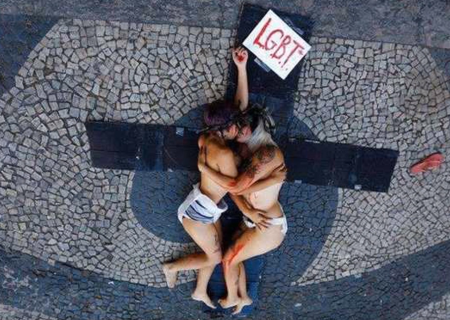 March 8, 2019 - Milano, Lombardia, Italy - A woman without a bra is seen  asking for body freedom next to a couple kissing during the protest..The  network Non Una di Meno