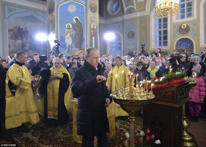 The Russian President lit a candle during the Christmas service at the Church of the Intercession of the Mother of God in Turginovo on January 6, 2016.
