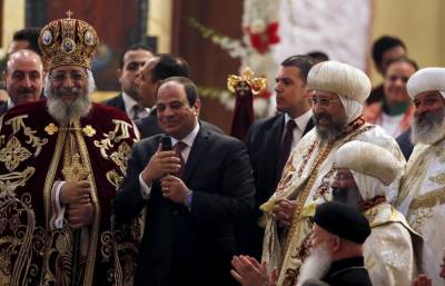 Egypt's President Abdel Fattah al-Sisi (C) greets Christians during Egypt's Coptic Christmas eve mass led by Pope Tawadros II (L), the 118th Pope of the Coptic Orthodox Church of Alexandria and Patriarch of the See of St. Mark Cathedral, in Cairo, Egypt, January 6, 2016.