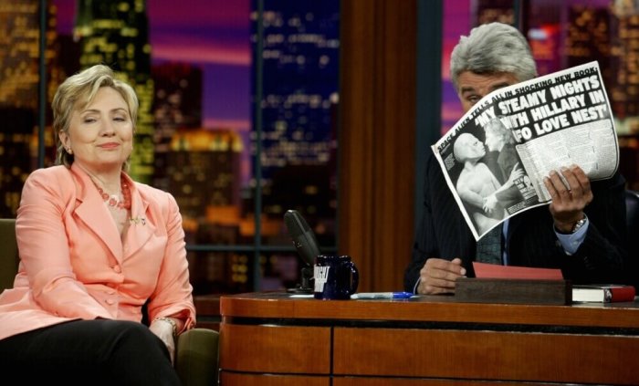 United States Senator Hillary Rodham Clinton, D-N.Y., appears as a guest on 'The Tonight Show with Jay Leno' at the NBC studios in Burbank, California, August 4, 2003, as host Jay Leno shows her a tabloid newspaper article about her appearance with a UFO alien.