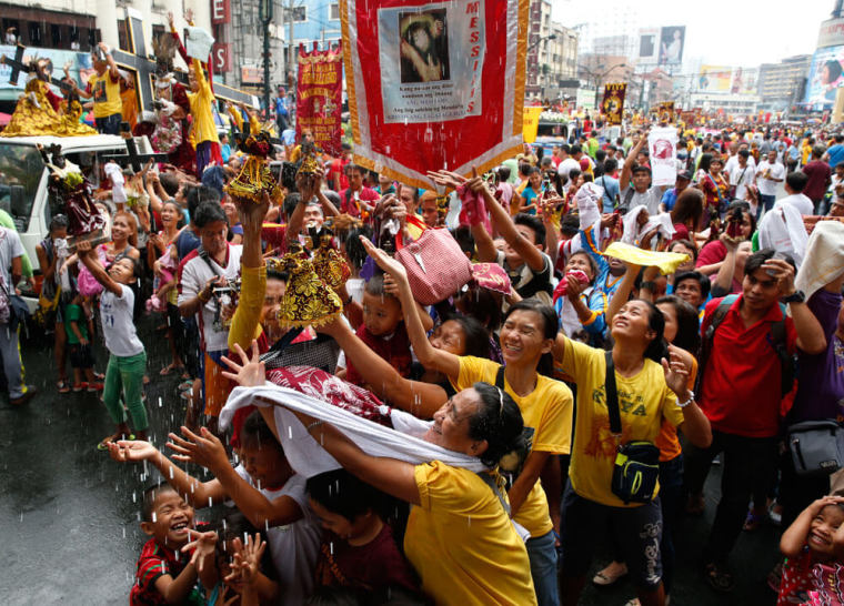 Devotees are sprinkled with holy water during a procession of Black Nazarene replicas two days before the annual procession of the Black Nazarene in Manila, Philippines January 7, 2016.