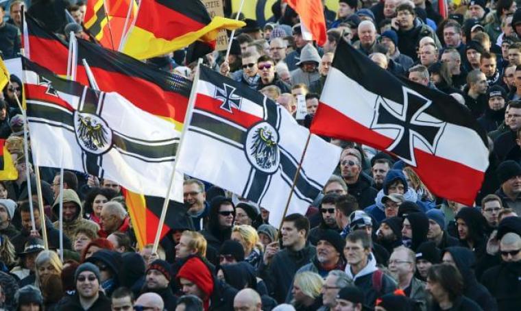 Supporters of anti-immigration right-wing movement PEGIDA (Patriotic Europeans Against the Islamisation of the West) carry various versions of the Imperial War Flag (Reichskriegsflagge) during a demonstration march in Cologne on January 9, 2016.