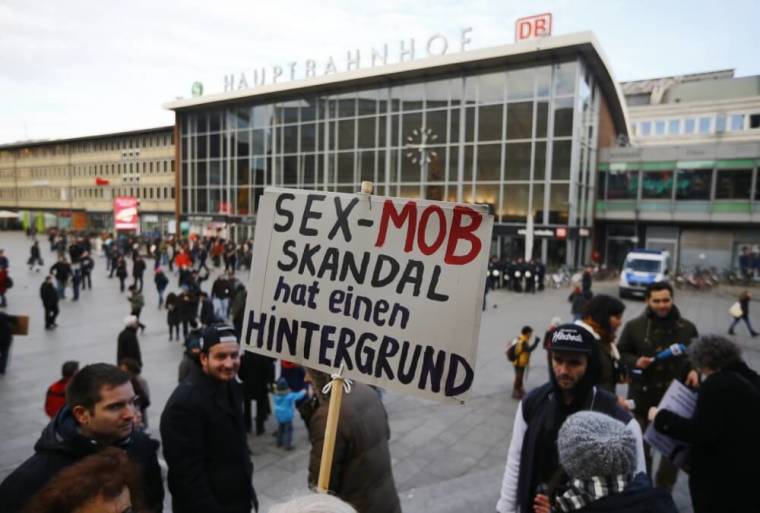 A person holds up a placard reading 'The sex mob scandal has a background' prior to a Patriotic Europeans Against the Islamization of the West (PEGIDA) demonstration march in front of the main train station in Cologne, Germany, January 9, 2016.