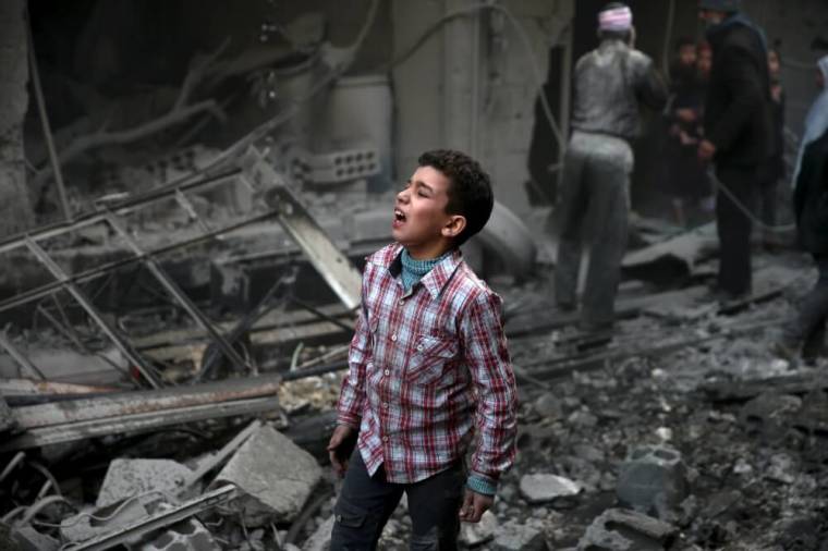 A boy reacts in a site hit by what activists said were airstrikes carried out by the Russian air force in the town of Douma, eastern Ghouta in Damascus, Syria, January 10, 2016.