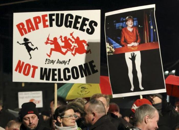 Members of LEGIDA, the Leipzig arm of the anti-Islam movement Patriotic Europeans Against the Islamisation of the West (PEGIDA), hold a placard showing German Chancellor Angela Merkel (R) as they take part in a rally in Leipzig, Germany, January 11, 2016.