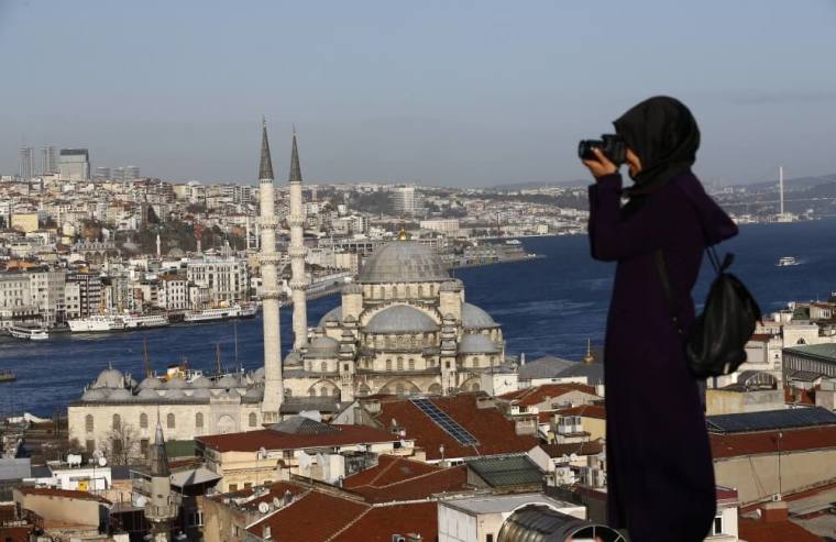 A woman takes photographs in front of the New Mosque by the Bosphorus strait in Istanbul, Turkey, January 12, 2016. A Syrian suicide bomber is thought to be responsible for an attack which killed at least ten people including foreigners in the heart of Istanbul's historic Sultanahmet tourist district on Tuesday, President Tayyip Erdogan said. There was a high probability Islamic State militants were behind the blast near the Blue Mosque and Hagia Sophia, major tourist sites in the center of one of the world's most visited cities, two senior Turkish security officials told Reuters.