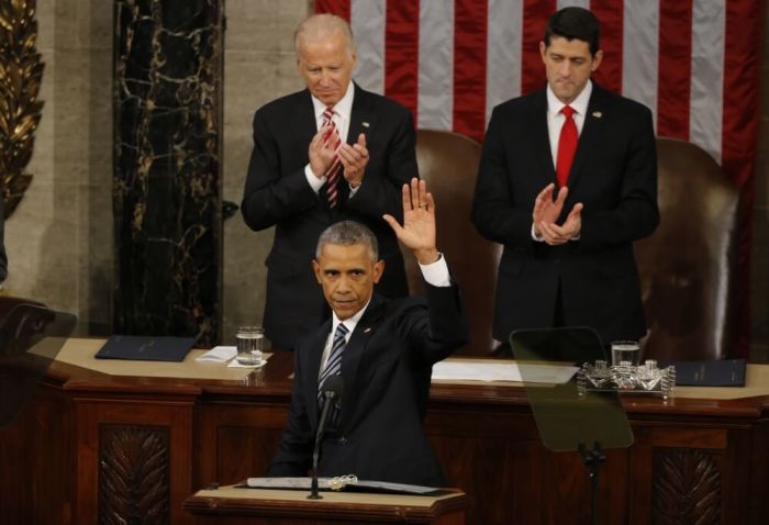 U.S. Vice President Joe Biden (L, rear) and Speaker of the House Paul Ryan (R, rear) applaud as U.S. President Barack Obama waves at the conclusion of his State of the Union address to a joint session of Congress in Washington, January 12, 2016.